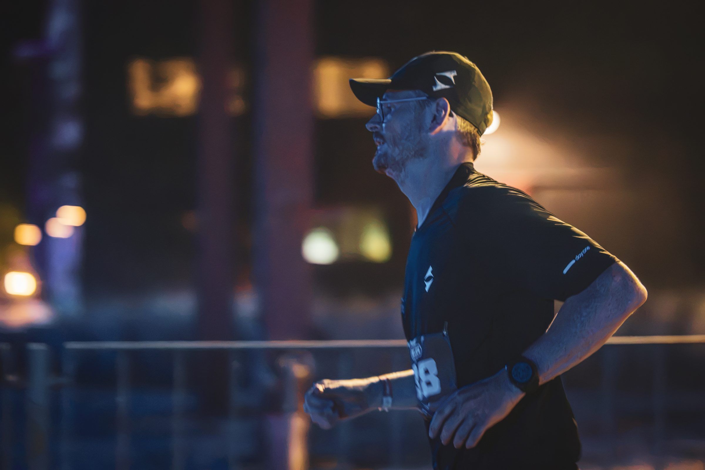Pierre in profile at night against blurred lights