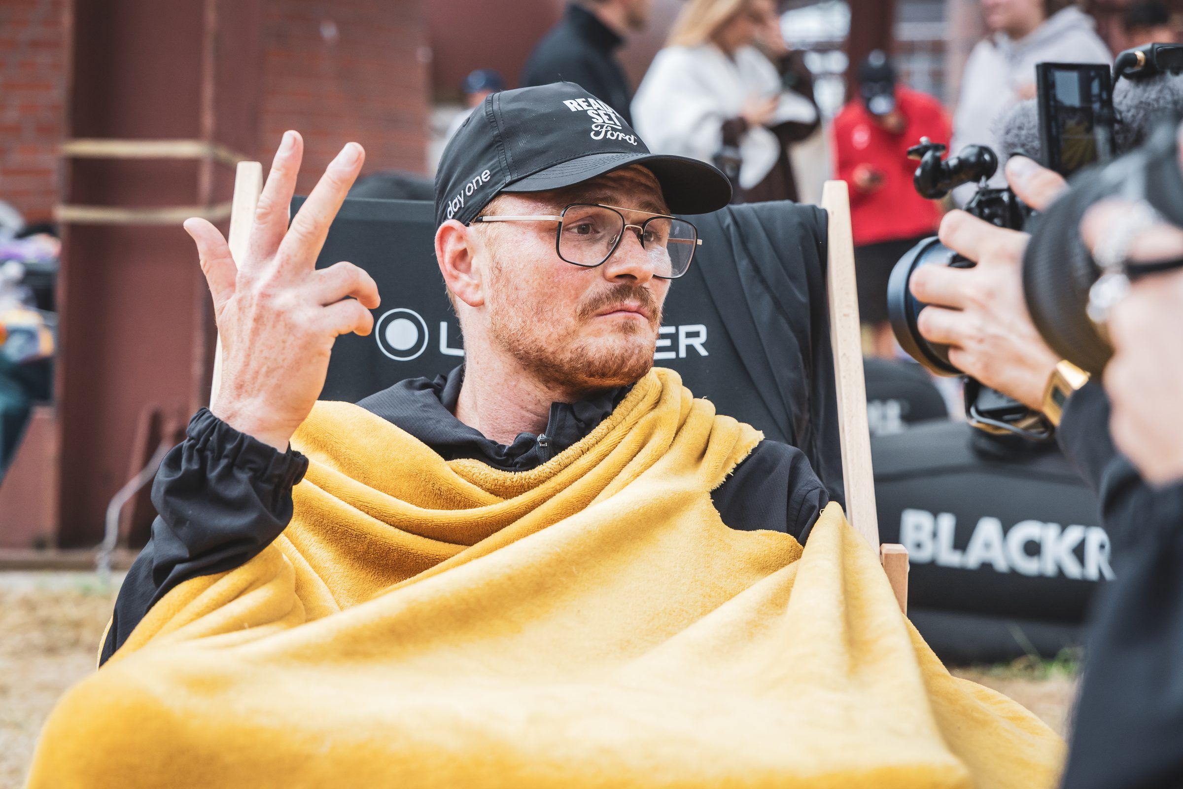 Pierre wrapped in a yellow blanket, making an OK sign