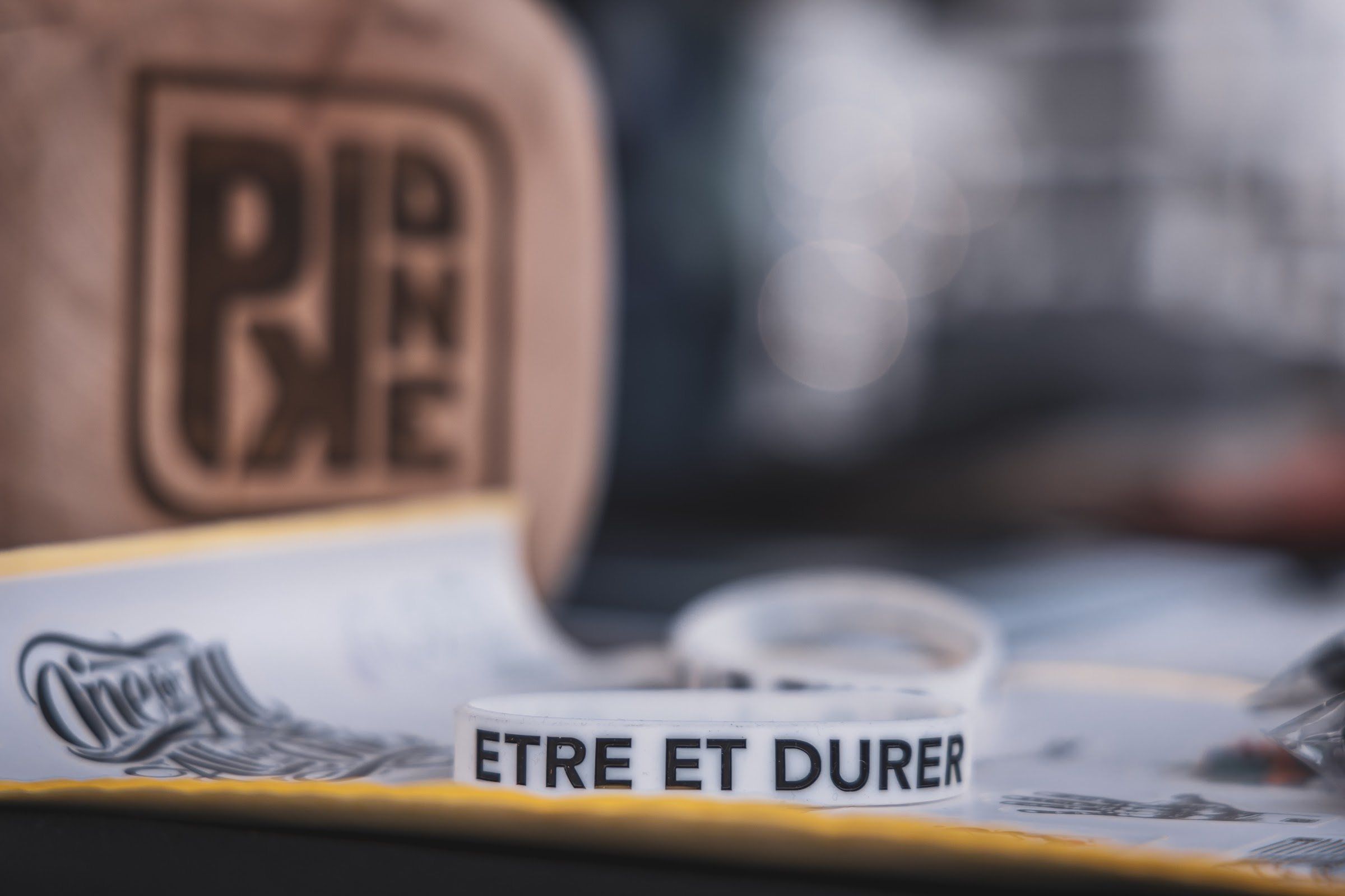 A wooden ParkourONE block and a wristband reading ETRE ET DURER on the merch table.